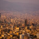 Ιράν-ΗΠΑ: Ένα Ηχηρό «Όχι» από τον Λευκό Οίκο στην Ειρηνευτική Πρόταση του Ιράν 1 Πανόραμα της Τεχεράνης με κτίρια και ορεινό φόντο, χαρακτηριστική εικόνα για άρθρο Ιράν‑ΗΠΑ.