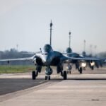 Ramstein Flag 26: Γιατί όλο το ΝΑΤΟ μιλάει για τους Έλληνες πιλότους των Rafale και F-16 1 Μαχητικά αεροσκάφη Rafale της Πολεμικής Αεροπορίας σε διάδρομο απογείωσης.