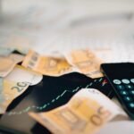 Υπολογιστής και χαρτονομίσματα ευρώ για την αξιολόγηση της ελληνικής οικονομίας